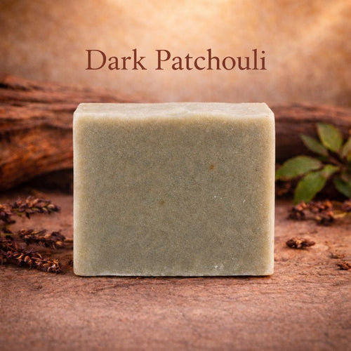 Bar of soap labeled 'Dark Patchouli' on a wooden surface with lavender and wood elements.