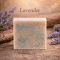 Bar of lavender soap on a wooden surface with lavender flowers.